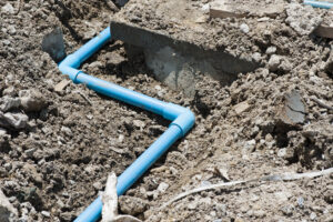 Blue PVC pipe laid in ground.