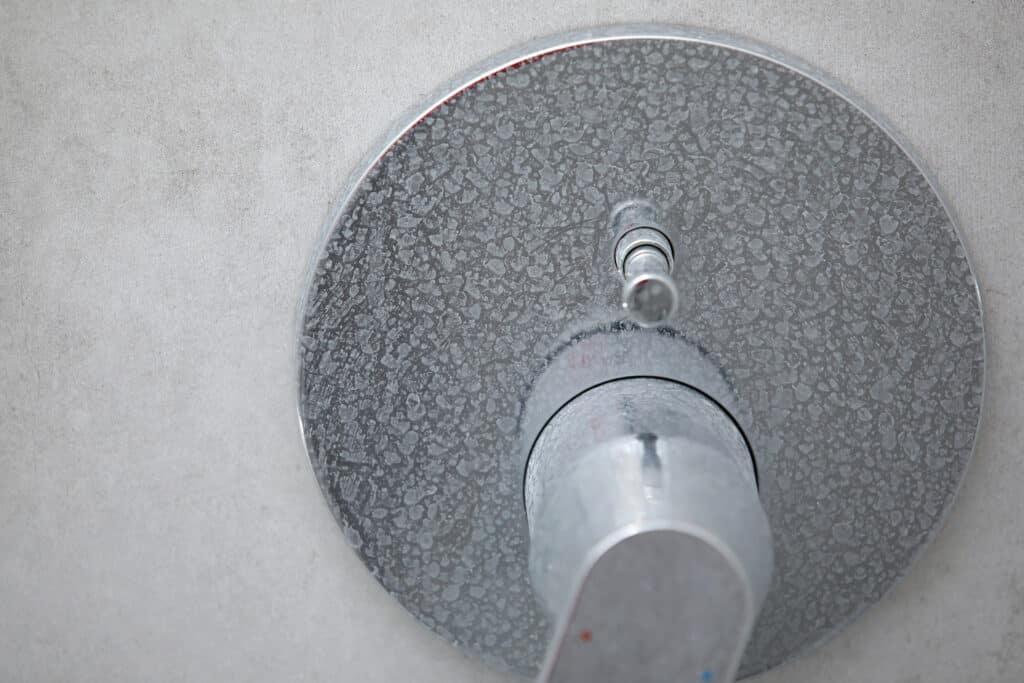 Limescale buildup on shower faucet from hard water